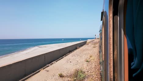 mirar por la ventana de un tren en calabria cerca del mar
