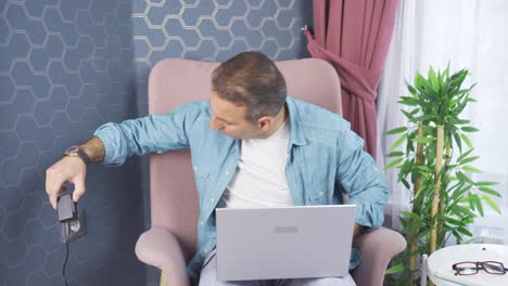 el hombre que se enchufa en un enchufe eléctrico roto en casa se enoja.