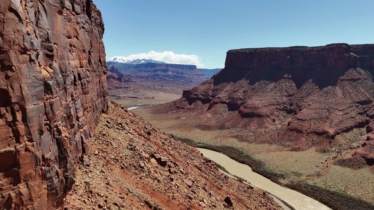 Panning around Butte Revealing Mountains and River, Aerial view, Highway 128, Moab Utah, La Sal Mountains, Colorado River
