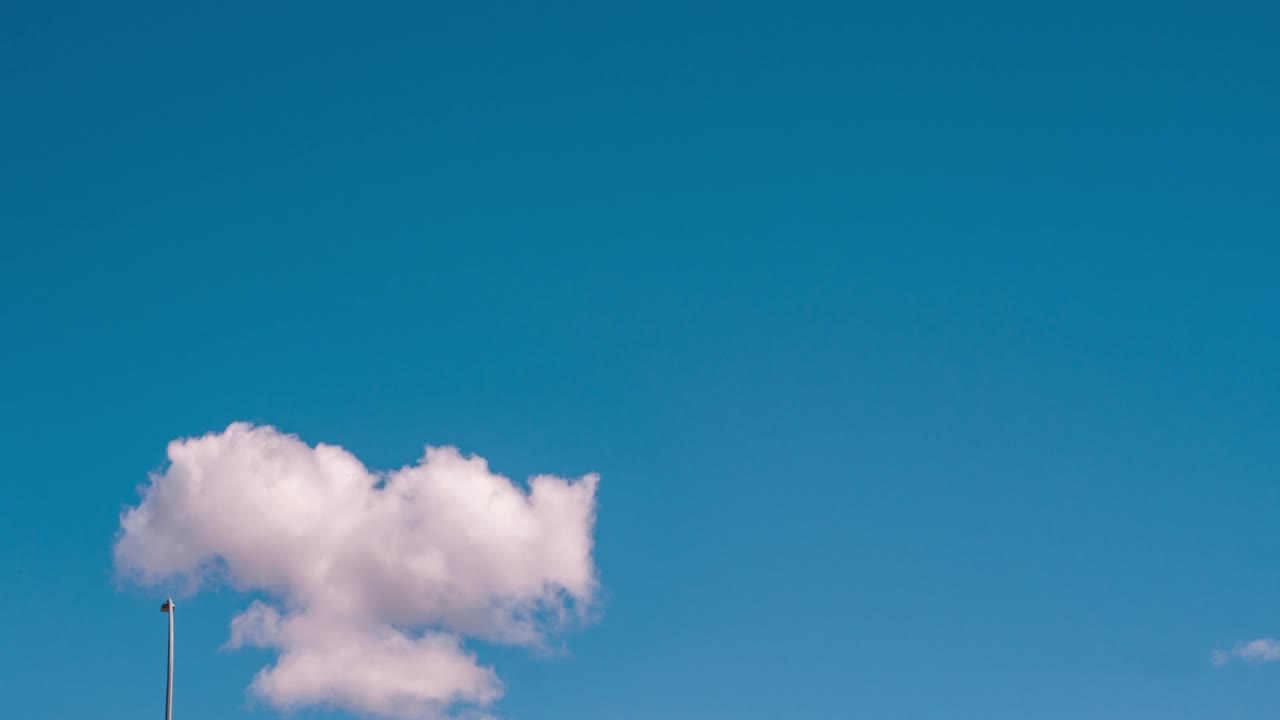 Timelapse cloudscape of a cotton candy fluffy white clouds flying in clear blue sky in sunny summer warm season. Good temperature in spring beautiful day. cloud moving high in the air wide space.