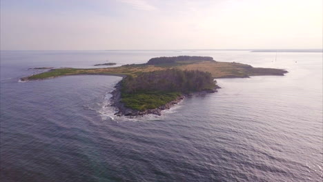 aerial shot flying over the deep blue atlantic ocean to richmond island off the maine coast