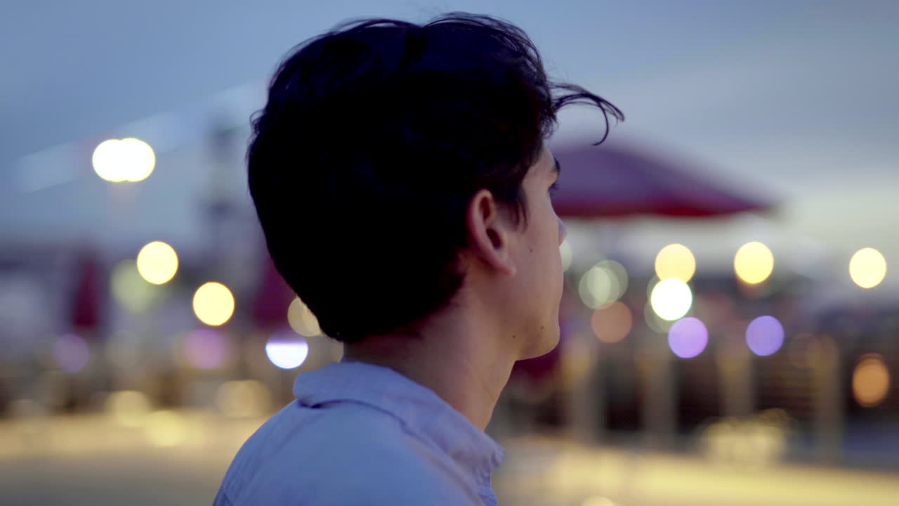 Man looking at city lights at night