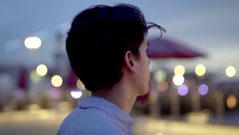 man looking at city lights at night
