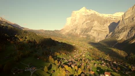 Drohnenaufnahmen-Aus-Der-Luft,-Die-über-Das-Dorf-Grindelwald-Drängen,-Mit-Blick-Auf-Den-Sonnenuntergang-Des-Wetterhorns