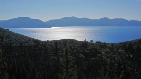 scenic view of serene and green forest, mountains and sea in kefalonia greece - wide shot