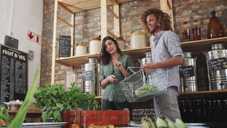 young couple buying fresh fruit and vegetables in sustainable plastic free grocery store