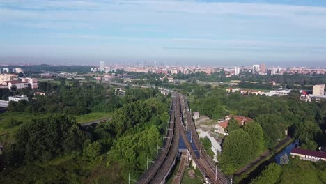 railway track intersection with skyline of milan city, aerial view