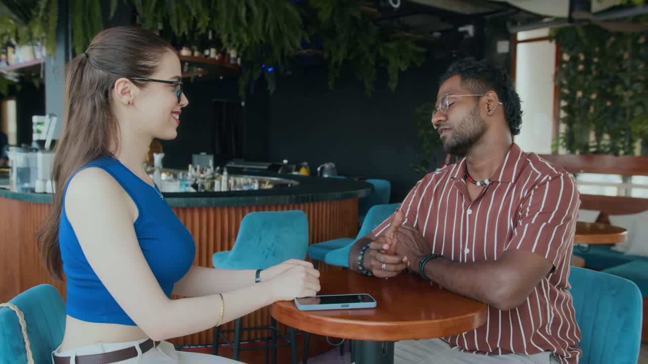 Cheerful Waiter Bringing Cocktails to Couple at Restaurant