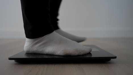 nervous pregnant woman shifting feet on scale in last weeks of pregnancy
