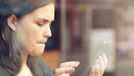 mujer usando una pantalla táctil de una tableta en un café