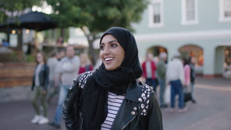 portrait of cute young muslim woman tourist using smartphone browsing social media app enjoying relaxed urban evening