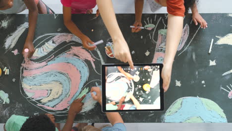 children drawing on a chalkboard