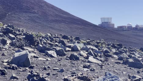 Cinematic-panning-shot-of-the-barren-rocky-landscape-near-the-Haleakala-Observatory-at-the-summit-of-Haleakala-in-Maui,-Hawai'i