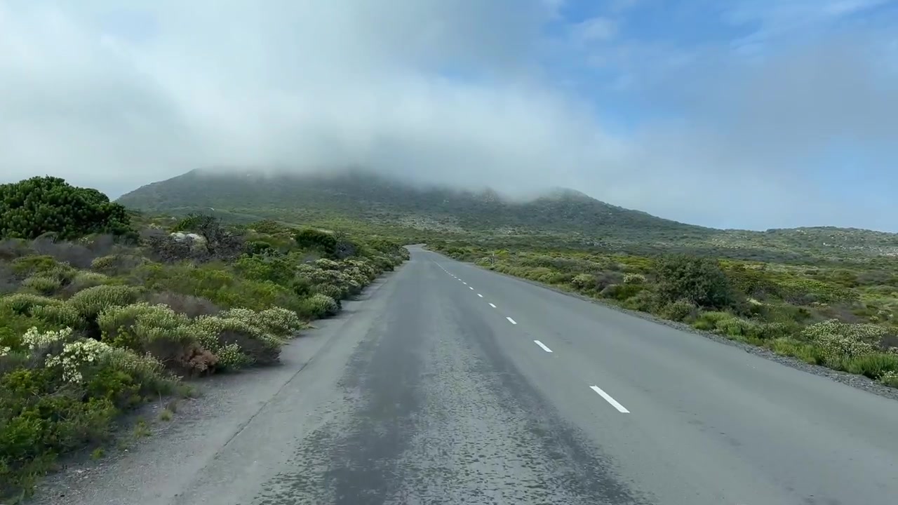 Nuvole alla deriva su una strada remota a Cape Point, Sudafrica.