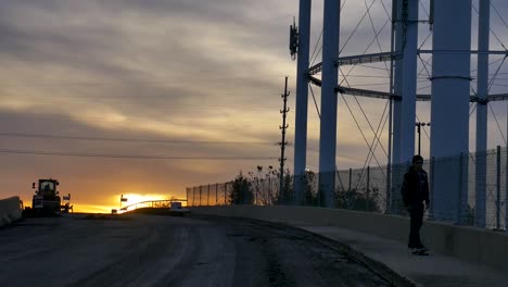 skater skates down the road during sunset