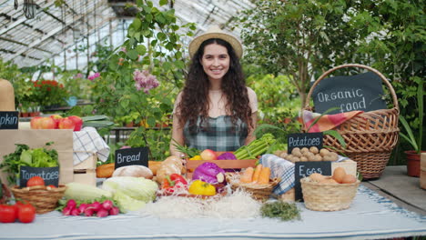 woman at a fresh produce stand in a greenhouse