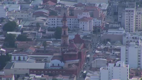 Autos-Y-Personas-Se-Mueven-Por-Las-Calles-De-Una-Ciudad-Entre-Edificios-Altos