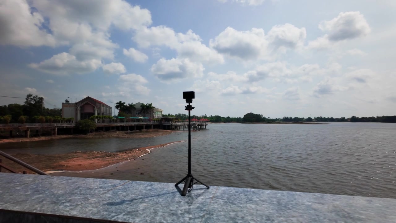 Kameraet fanger skønheden ved Cong Vien ven ho Ba To i Vung Tau, Vietnam. Solen skinner klart over vandet med synlige refleksioner. Området viser naturlig natur og rolige omgivelser.