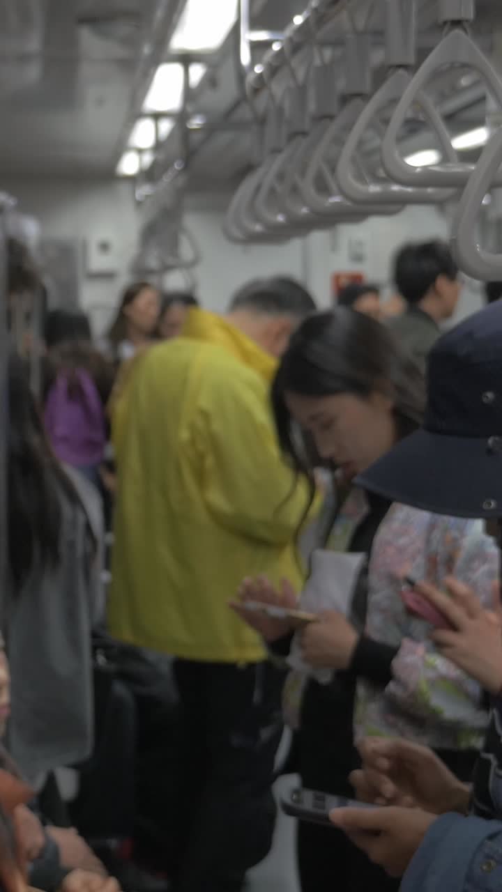 Gerbong Kereta Bawah Tanah yang Ramai dengan Para Komuter Menggunakan Ponsel