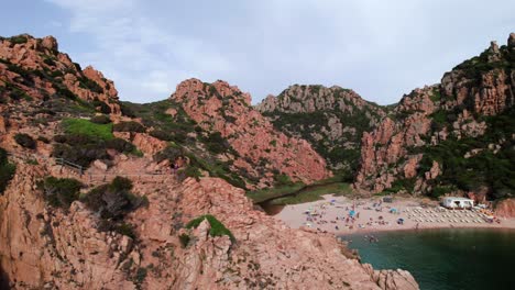 revelación aérea de un turista en una playa remota en una bahía rocosa costa de cerdeña