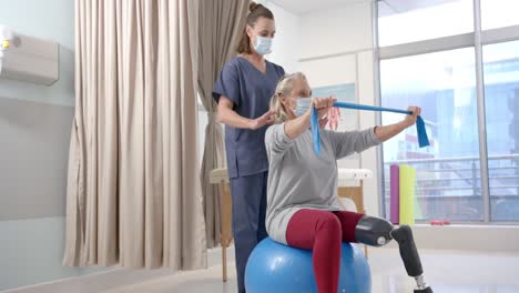 Fisioterapeuta-Femenina-Caucásica-Y-Paciente-Senior-Con-Prótesis-De-Pierna-Haciendo-Ejercicio