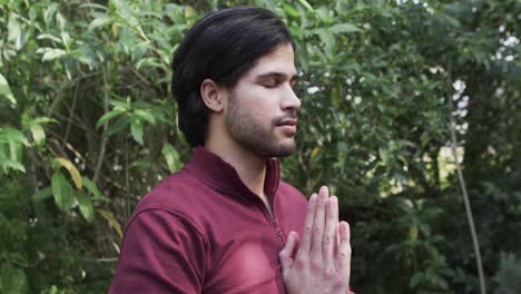 focused caucasian man practicing yoga meditation in nature, slow motion