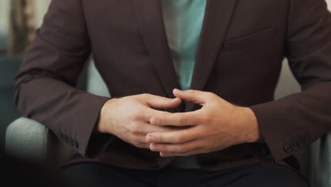 Primer-Plano-De-Manos-Masculinas-Gesticulando-Contra-El-Fondo-De-Una-Chaqueta-Elegante