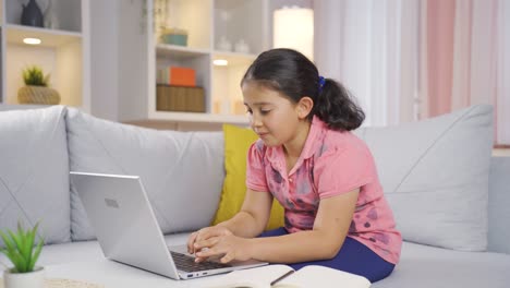 niña mirando la computadora portátil haciendo un gesto positivo.