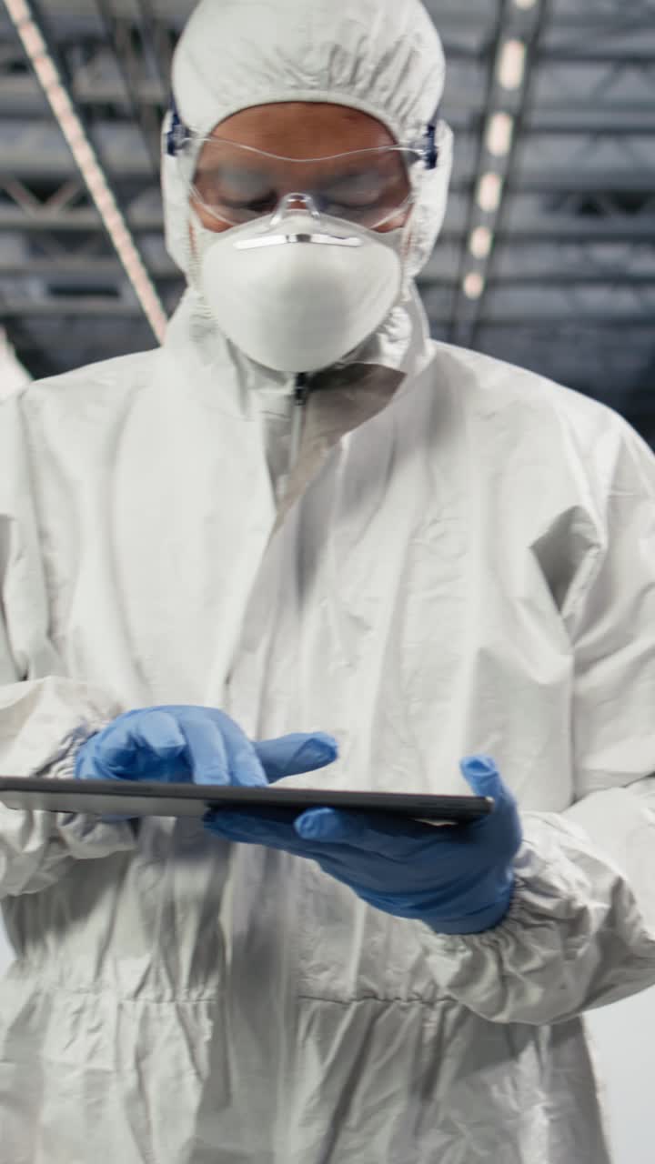 Video verticale: Tracciamento lotti di fabbricazione semiconduttori, tablet e operaio in camera bianca