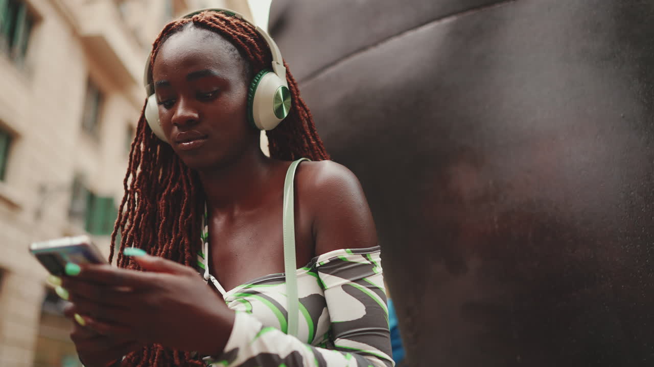 Donna che usa lo smartphone con le cuffie in città