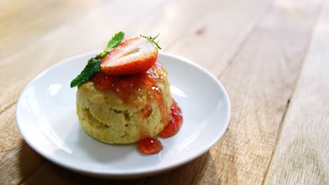 sweet food in plate on wooden table