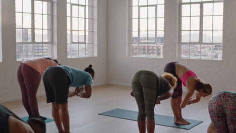 Hermoso-Instructor-De-Clase-De-Yoga-Enseñando-A-Un-Grupo-Joven-Practicando-Pose-De-Flexión-Hacia-Adelante-Disfrutando-De-Un-Estilo-De-Vida-Saludable-Haciendo-Ejercicio-En-El-Estudio-Al-Amanecer