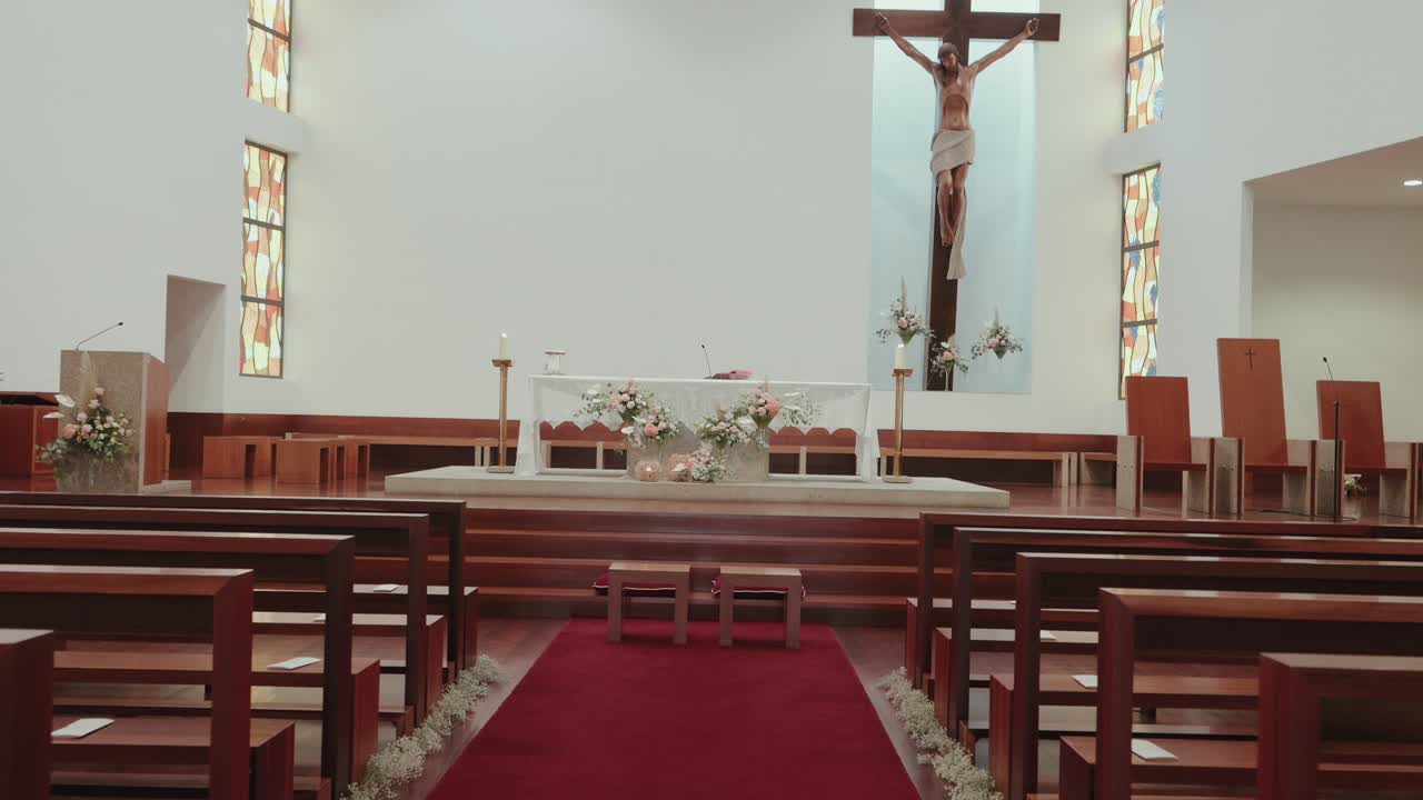 Elegant church interior with floral arrangements and red carpet for a wedding event