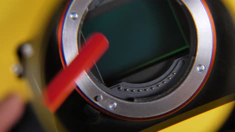 close up shot of hand cleaning lens from dust with brush looking through magnifier