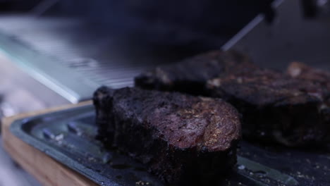 espeso y jugoso filete de carbón fumando en la parrilla al aire libre, cerca de la profundidad poco profunda del campo