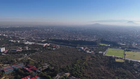 Drone flying backwards, providing a receding view of eastern Mexico City
