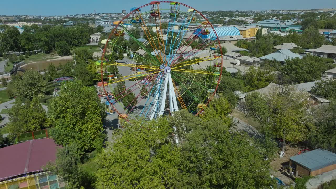 rueda de la fortuna colorida en el parque de atracciones abandonado en sayram cerca de shymkent, kazajstán