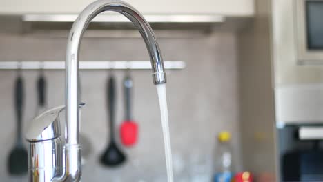 agua que se vierte de un grifo en cámara lenta