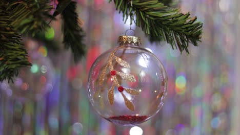 bola de cristal de navidad con adornos de brillo rojo y dorado en el árbol