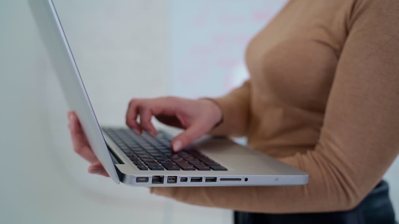 Typing on laptop, close up. Close up of female hands typing text on laptop keyboard