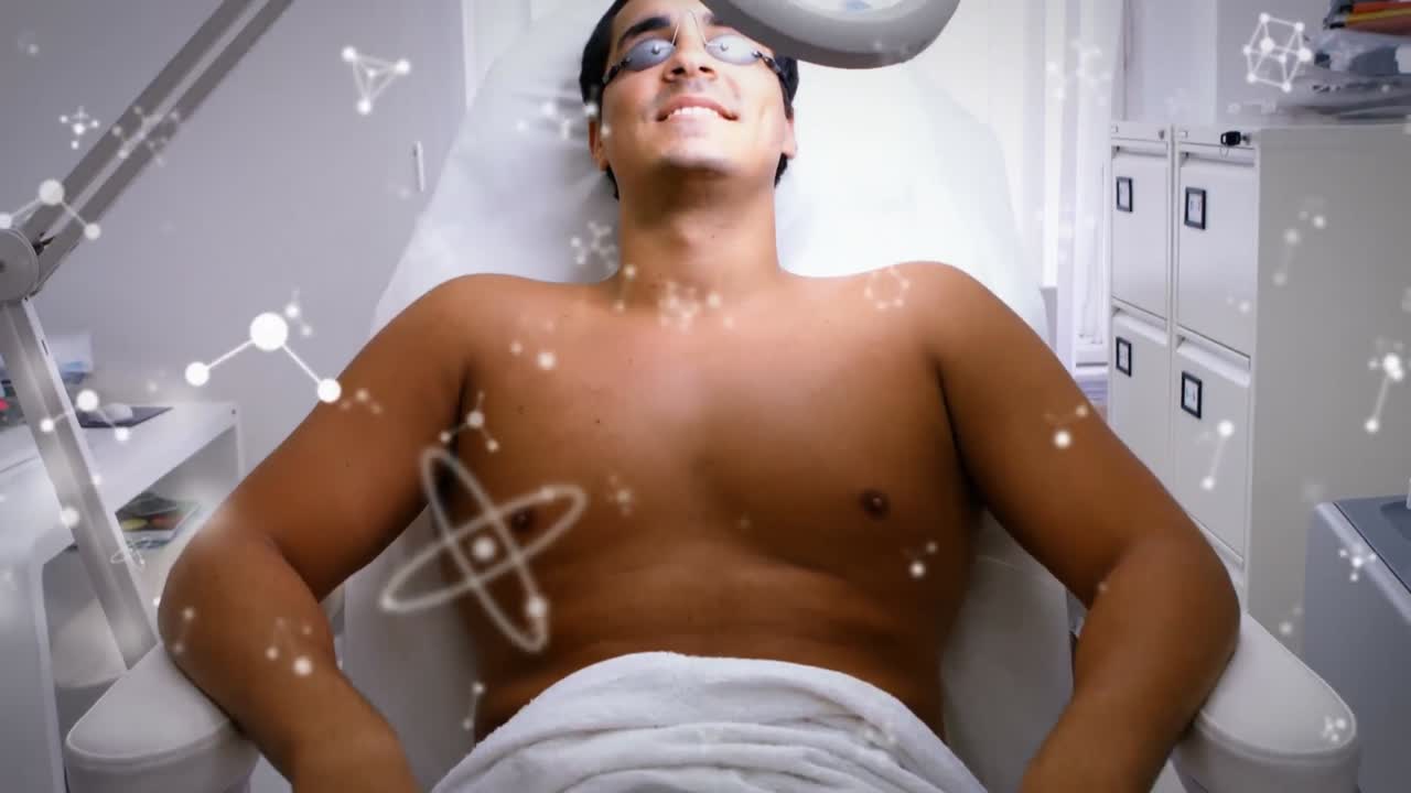 병원 침대에 누워 있는 두 인종의 남성 환자 위의 분자의 애니메이션