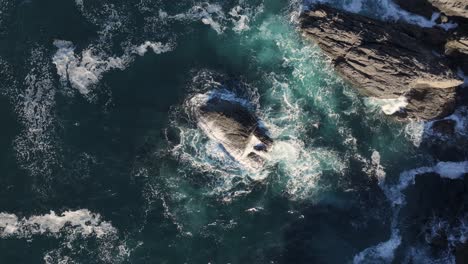 aerial view of dramatic ocean waves crashing against rocky coast