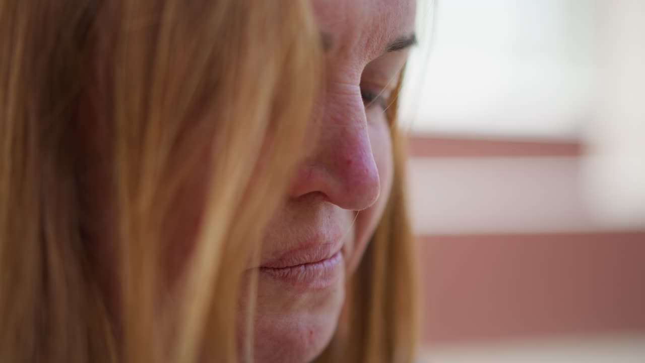 Extreme close up of crying girl wiping tears with napkin, emotional face showing deep sadness and vulnerability, hair partially covering face, captured in soft daylight