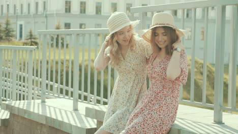 two young women wearing dresses and straw hats outdoors