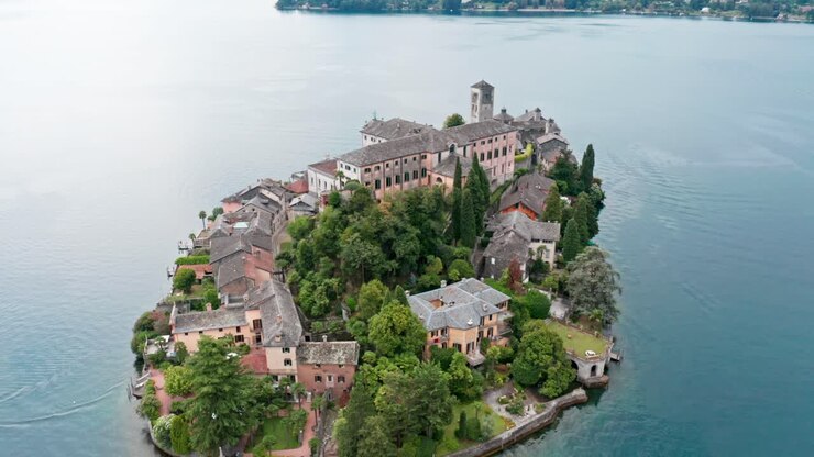 Isola di San Giulio sul Lago d'Orta, Italia, con edifici storici e vegetazione lussureggiante, vista aerea