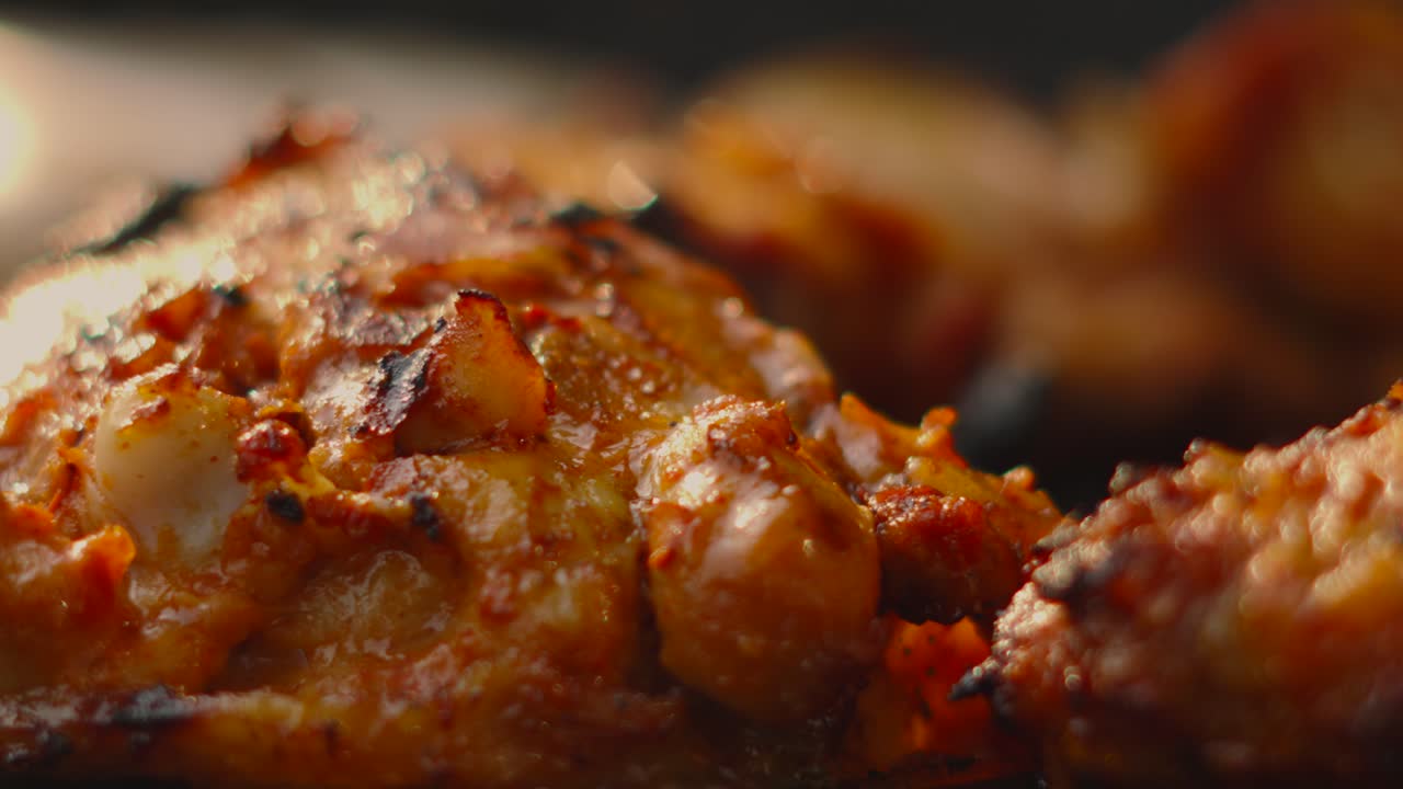 Slow Moving Macro Close Up of Delicious Marinated Chicken Thighs with Crispy Skin and Shallow Depth of Field. Tasty Nutritious Summer Cooking Food