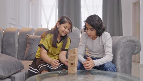 happy indian kids playing jenga at home