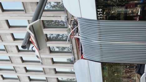 Vertical-portrait-of-electric-bus-charging-renewable-electricity-at-the-energy-station