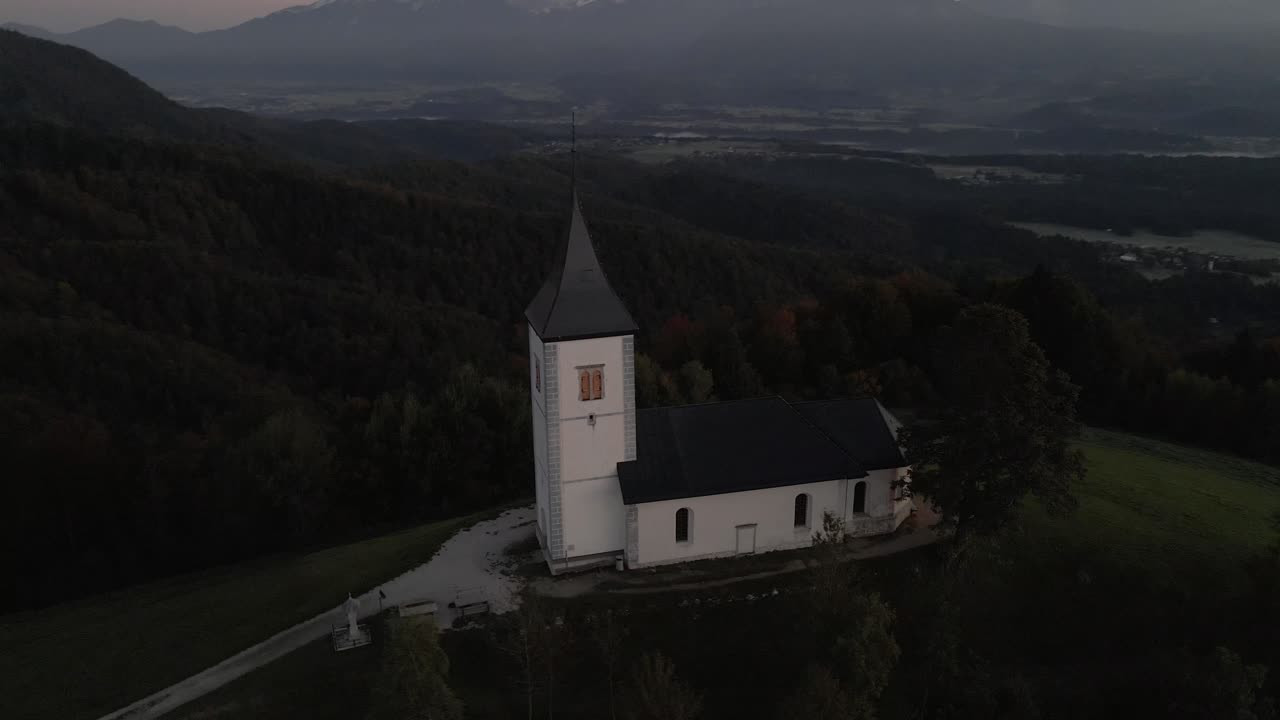 Morning light on St. Primoz church and majestic Julian Alps, seen from above Slovenia