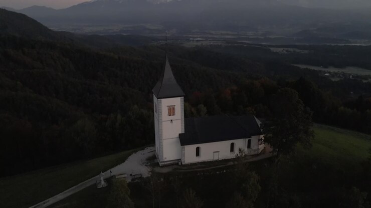 Morning light on St. Primoz church and majestic Julian Alps, seen from above Slovenia